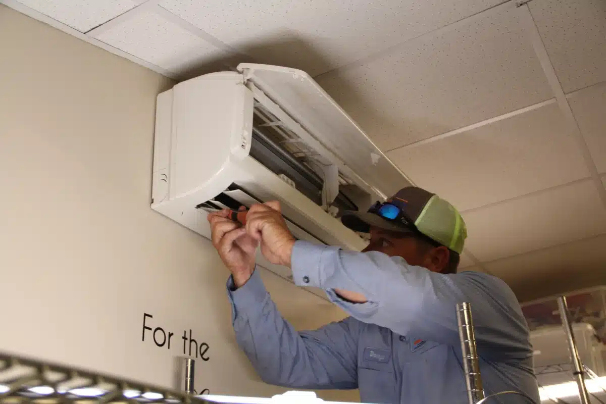 Worker doing maintenance work on an indoor air conditioning unit
