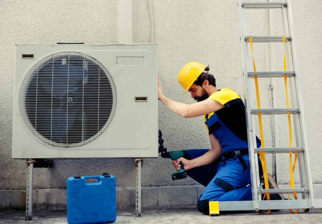competent repairman starting work defective air conditioner using handheld drill disassemble condenser metal coil panel precise mechanic dismantling hvac system check dirt 1 1