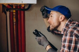 Blogs 17 HVAC technician inspecting a furnace with a flashlight